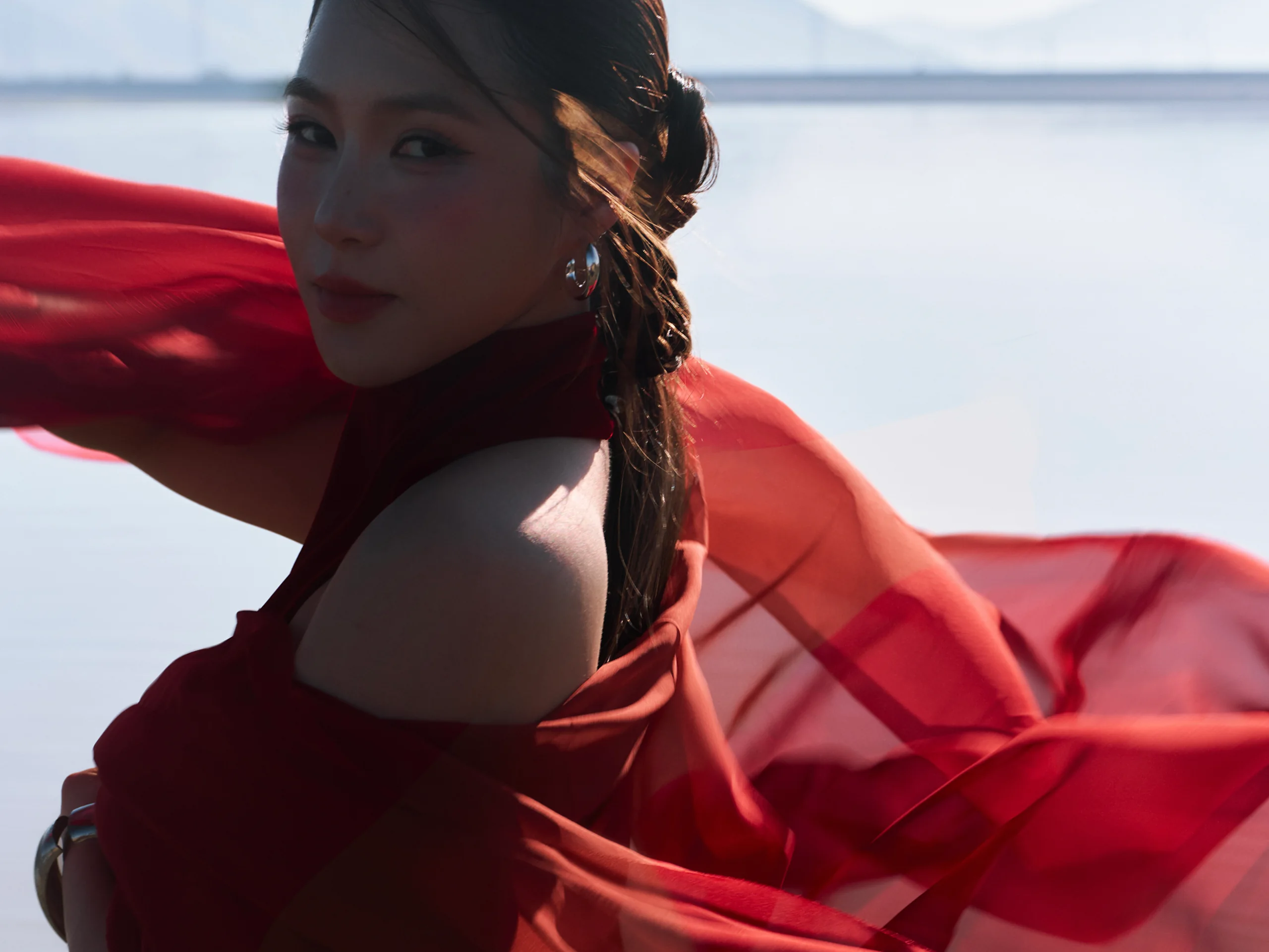 Hương Tràm với chiếc khăn lụa đỏ bay trong gió